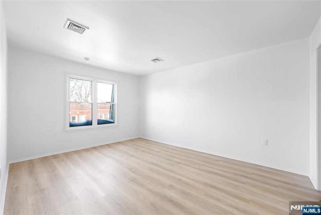253 Park Avenue, Unit 304 Rutherford, NJ 07070 - Photo 20 of 23 an empty room with wooden floor and windows