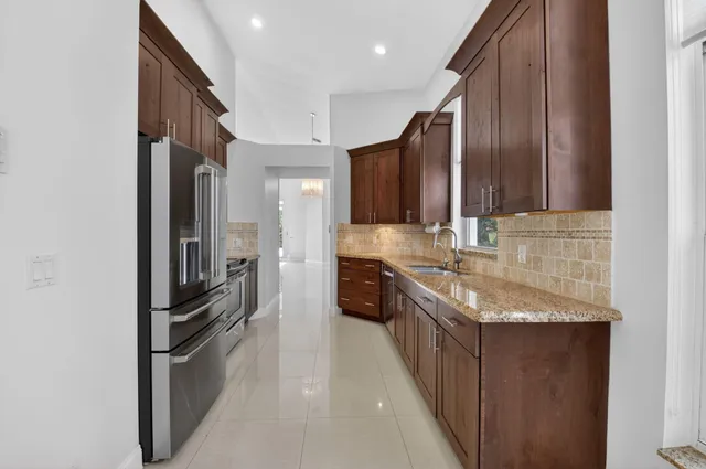 a kitchen with stainless steel appliances granite countertop a refrigerator and a sink