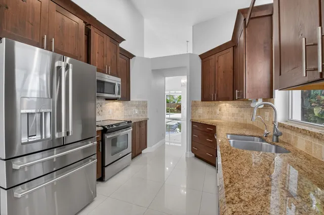 a kitchen with stainless steel appliances granite countertop a refrigerator sink and stove