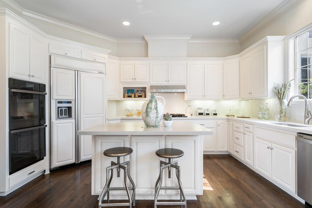 1700 Easton Drive Burlingame, CA 94010 - Photo 28 of 69 a kitchen with stainless steel appliances white cabinets and wooden floors