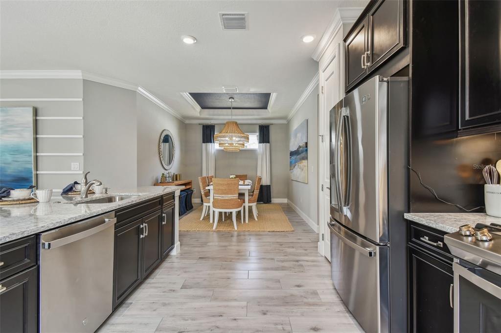 4257 Rosatti Road Wesley Chapel, FL 33543 - Photo 12 of 96 a kitchen with stainless steel appliances granite countertop hardwood floor sink stove dining table and chairs