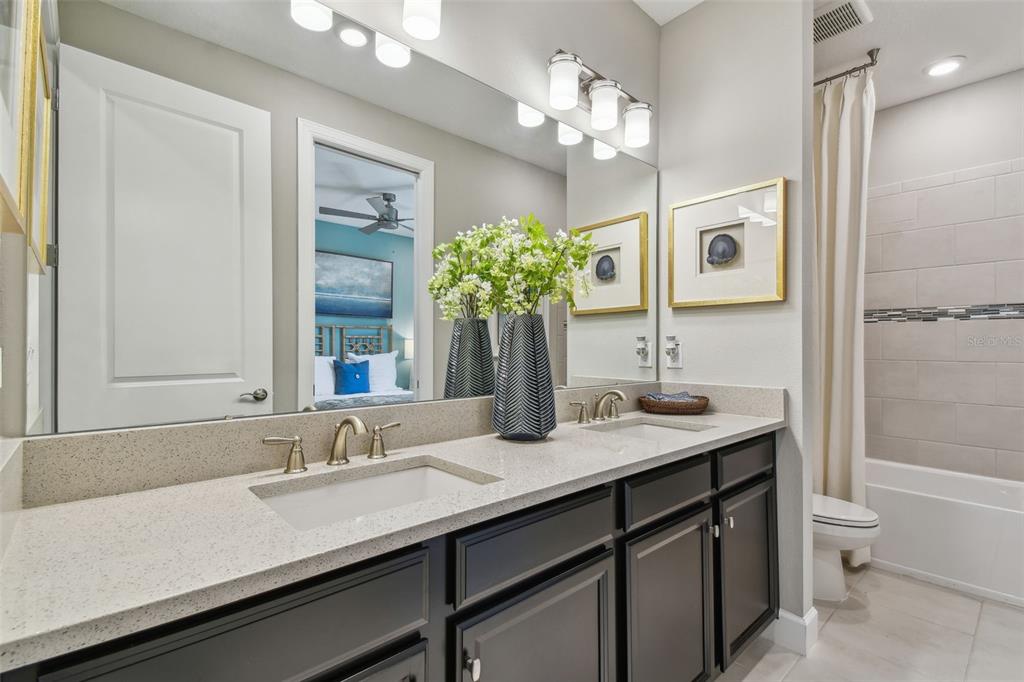 4257 Rosatti Road Wesley Chapel, FL 33543 - Photo 39 of 96 a bathroom with a granite countertop sink a toilet and a large mirror