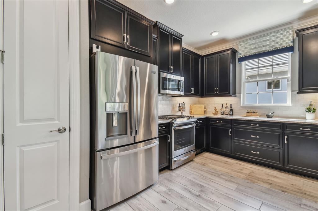 4257 Rosatti Road Wesley Chapel, FL 33543 - Photo 6 of 96 a kitchen with granite countertop a refrigerator stove and sink