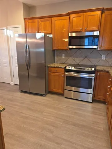 a kitchen with granite countertop a refrigerator and a sink