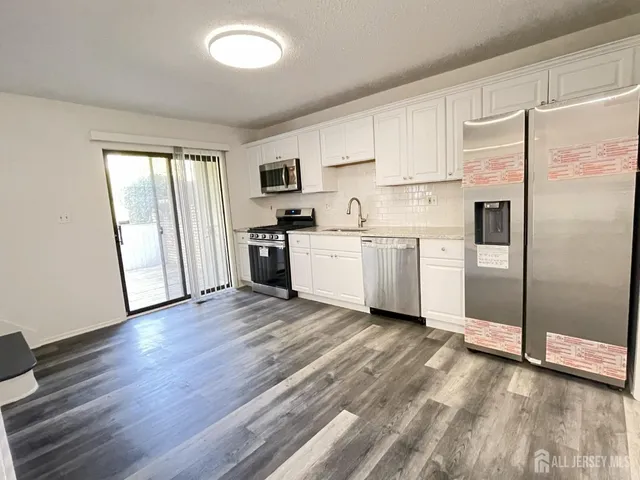 a kitchen with stainless steel appliances a refrigerator sink and cabinets