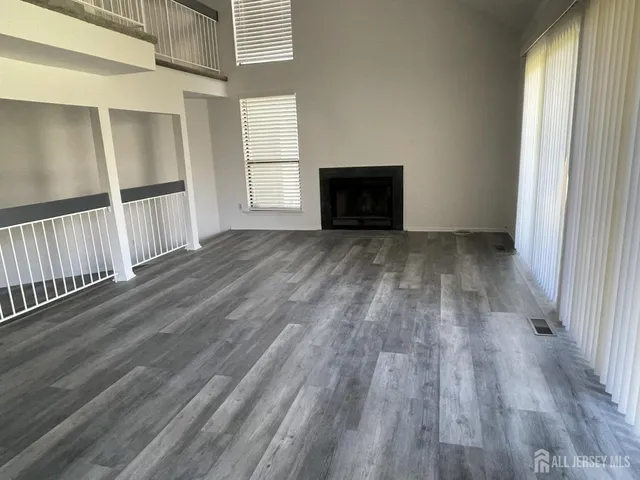 a view of empty room with wooden floor and fireplace