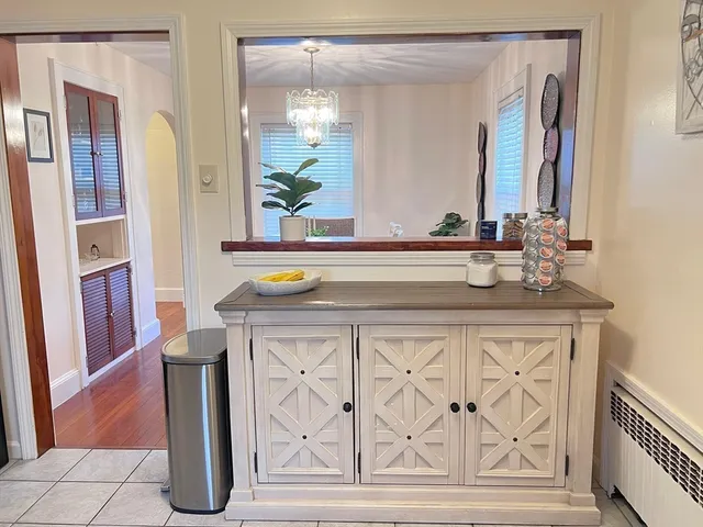 a view of a dining room with furniture a chandelier and wooden floor