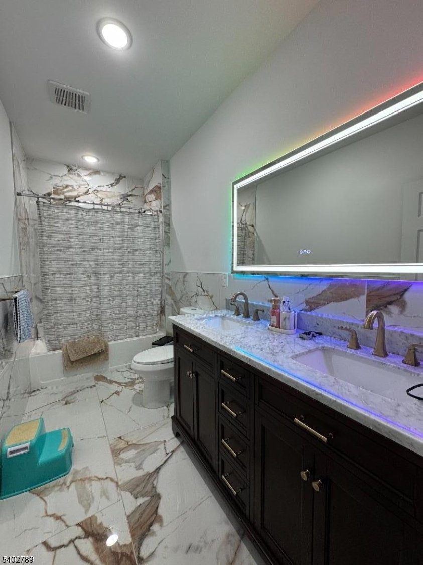 528 Jefferson Avenue Elizabeth, NJ 07201 - Photo 13 of 19 a bathroom with a double vanity sink toilet and shower