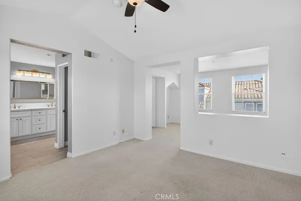 an empty room with ceiling fan and window