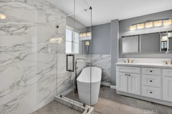 a bathroom with a double vanity sink mirror and bathtub