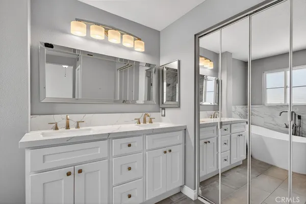 a bathroom with a granite countertop sink mirror and bathtub