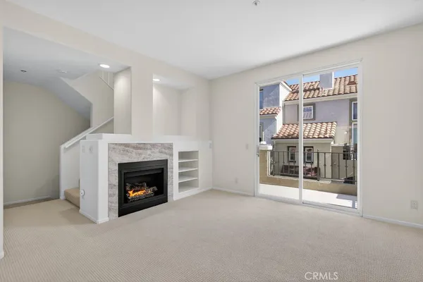 an empty room with windows and fireplace