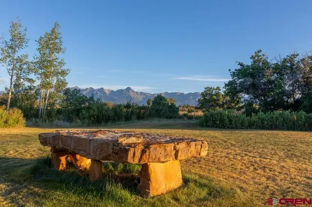 a kitchen with a dining table chairs and wooden floor