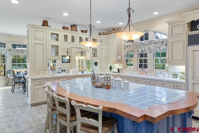 a dining table with chairs and kitchen view