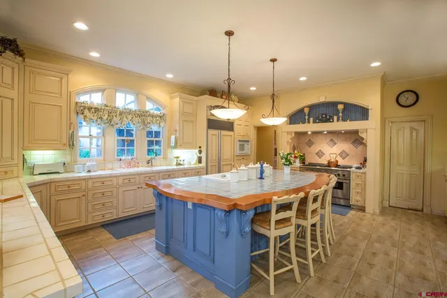 a kitchen with stainless steel appliances kitchen island granite countertop a stove a sink and a refrigerator