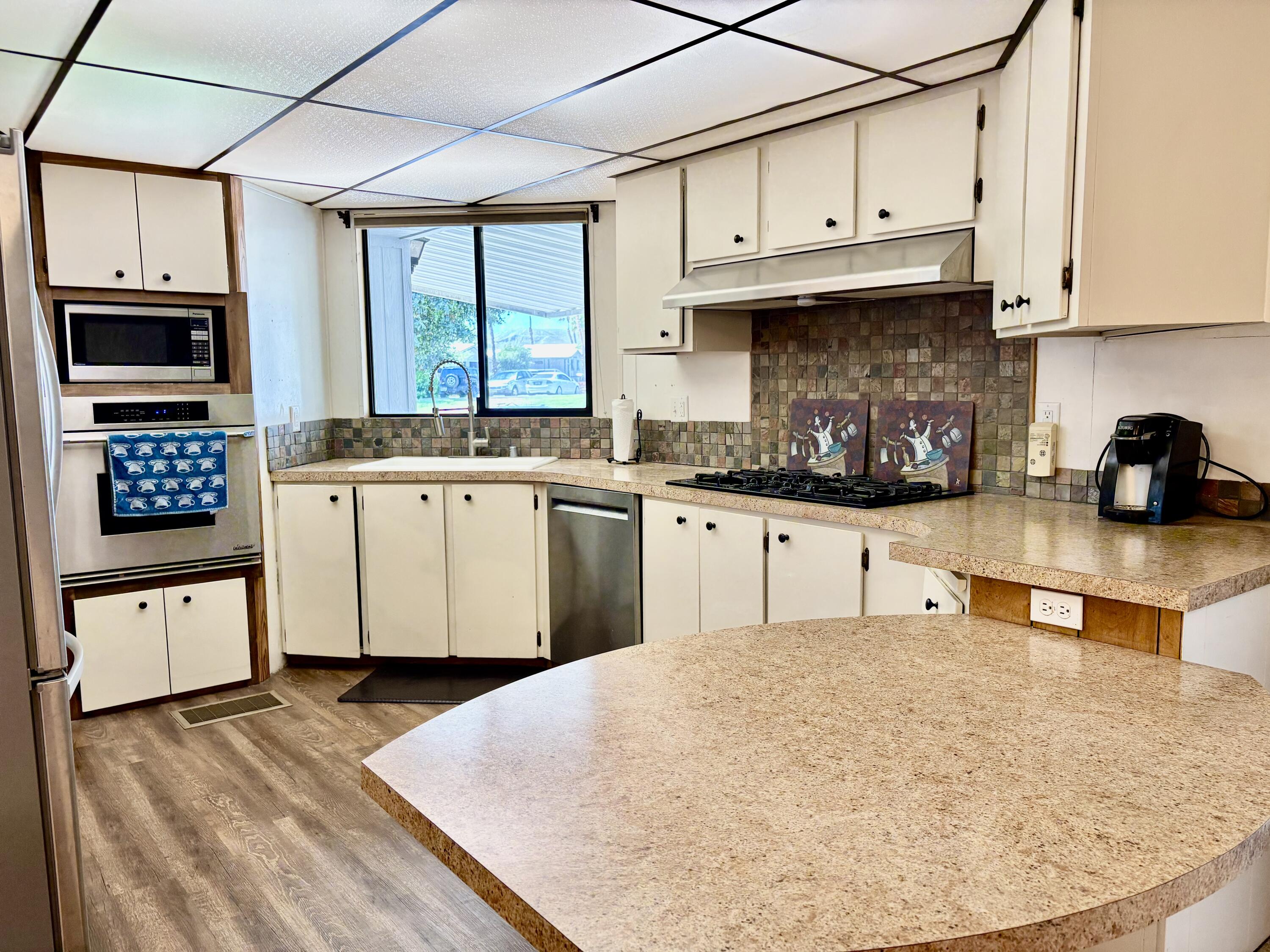 74711 Dillon Road, Unit 387 Desert Hot Springs, CA 92241 - Photo 13 of 50 a kitchen with stainless steel appliances granite countertop a stove sink and cabinets