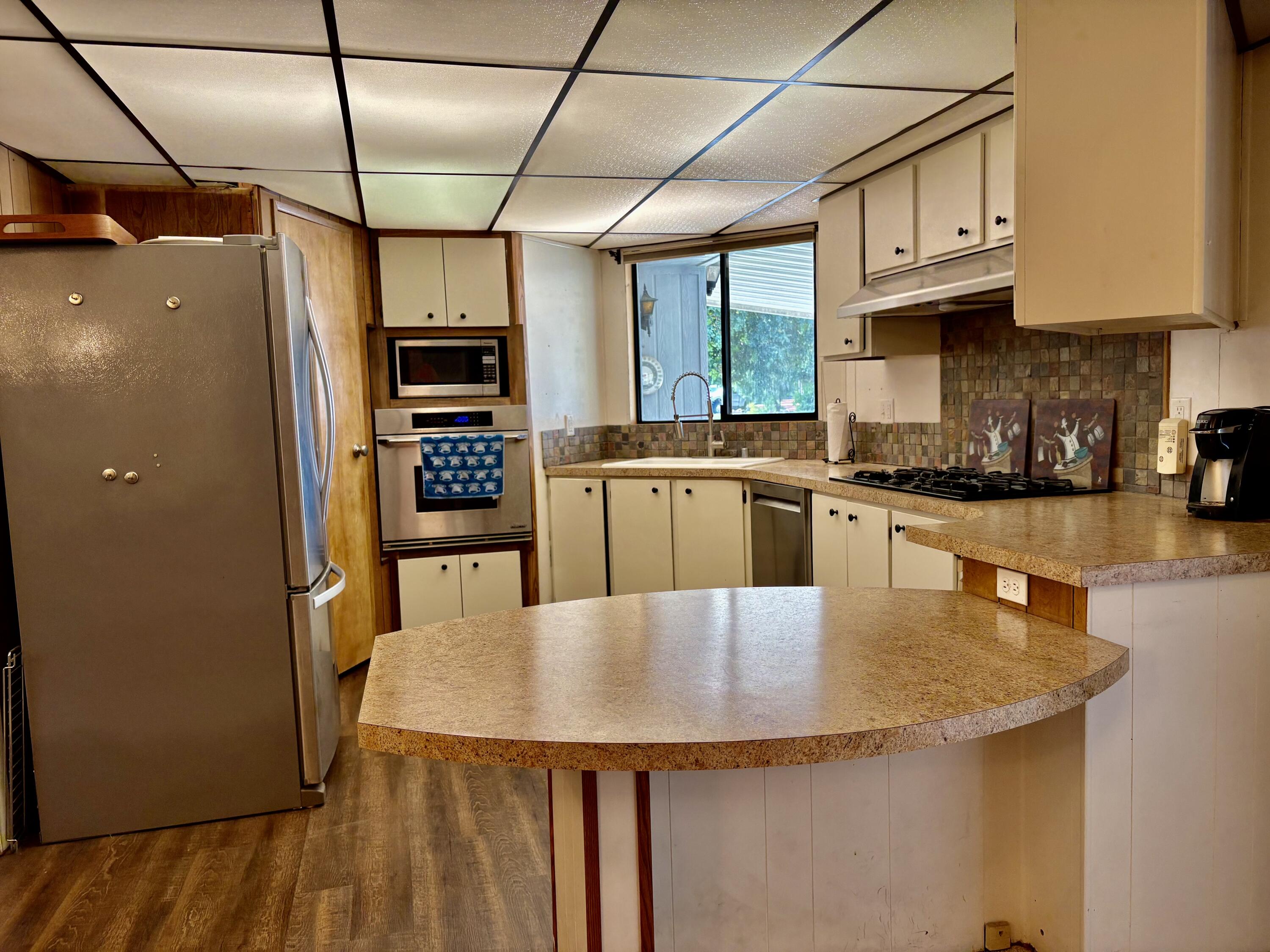 74711 Dillon Road, Unit 387 Desert Hot Springs, CA 92241 - Photo 14 of 50 a kitchen with stainless steel appliances granite countertop a sink a stove and refrigerator