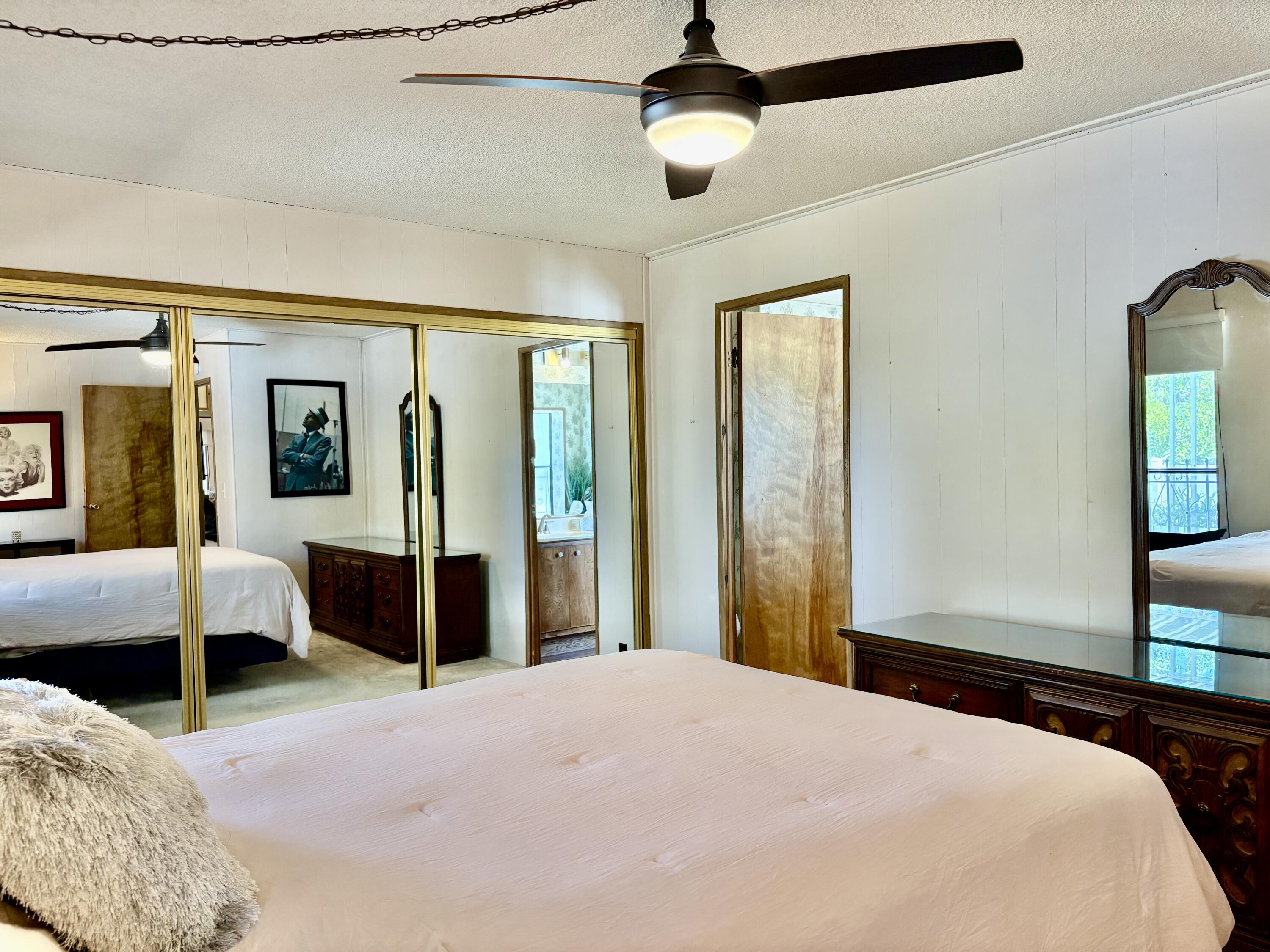 74711 Dillon Road, Unit 387 Desert Hot Springs, CA 92241 - Photo 17 of 50 a bedroom with a large bed and a chandelier