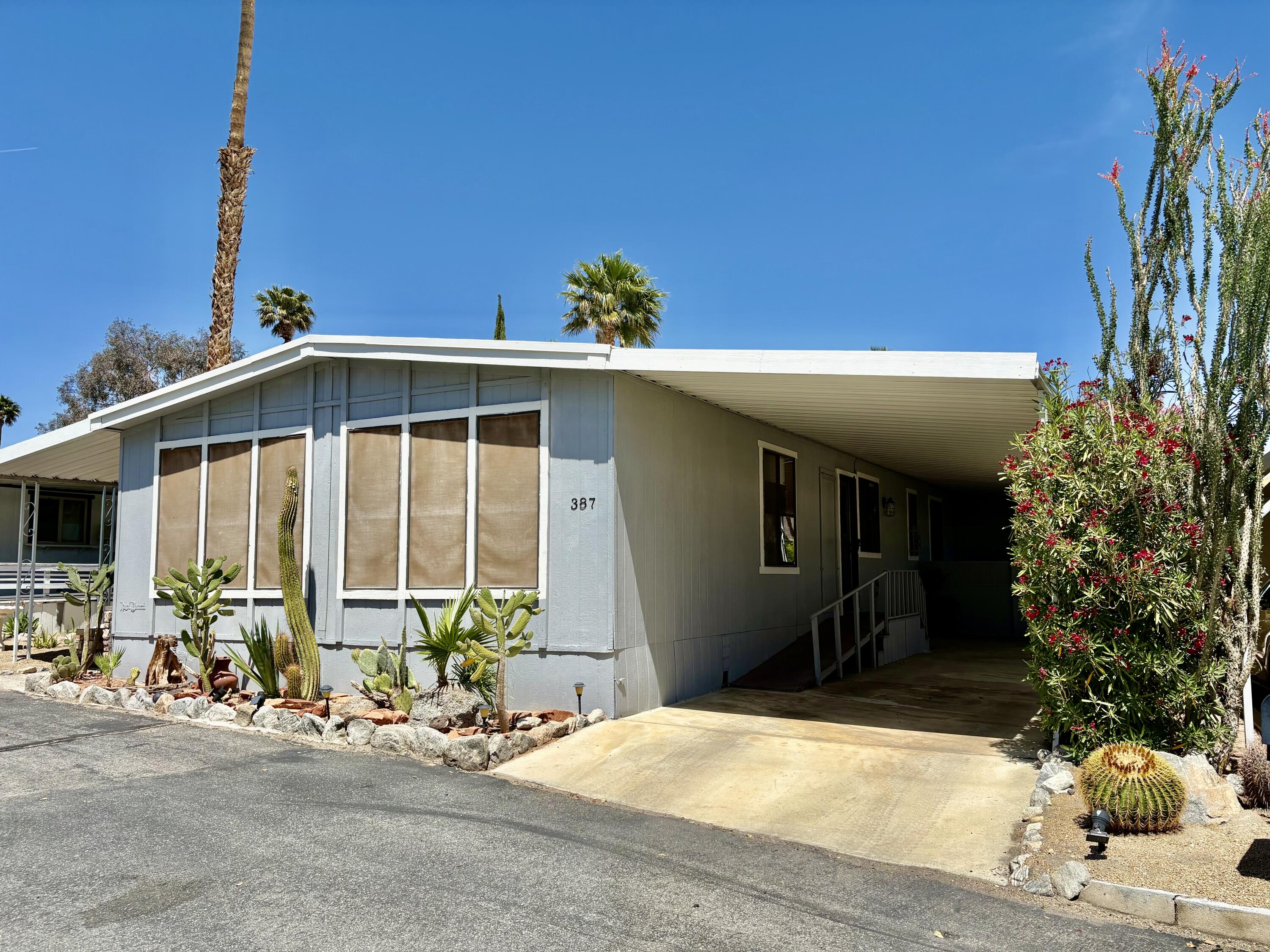74711 Dillon Road, Unit 387 Desert Hot Springs, CA 92241 - Photo 2 of 50 a front view of a house with lots of trees