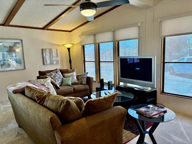 a living room with furniture a flat screen tv and a table