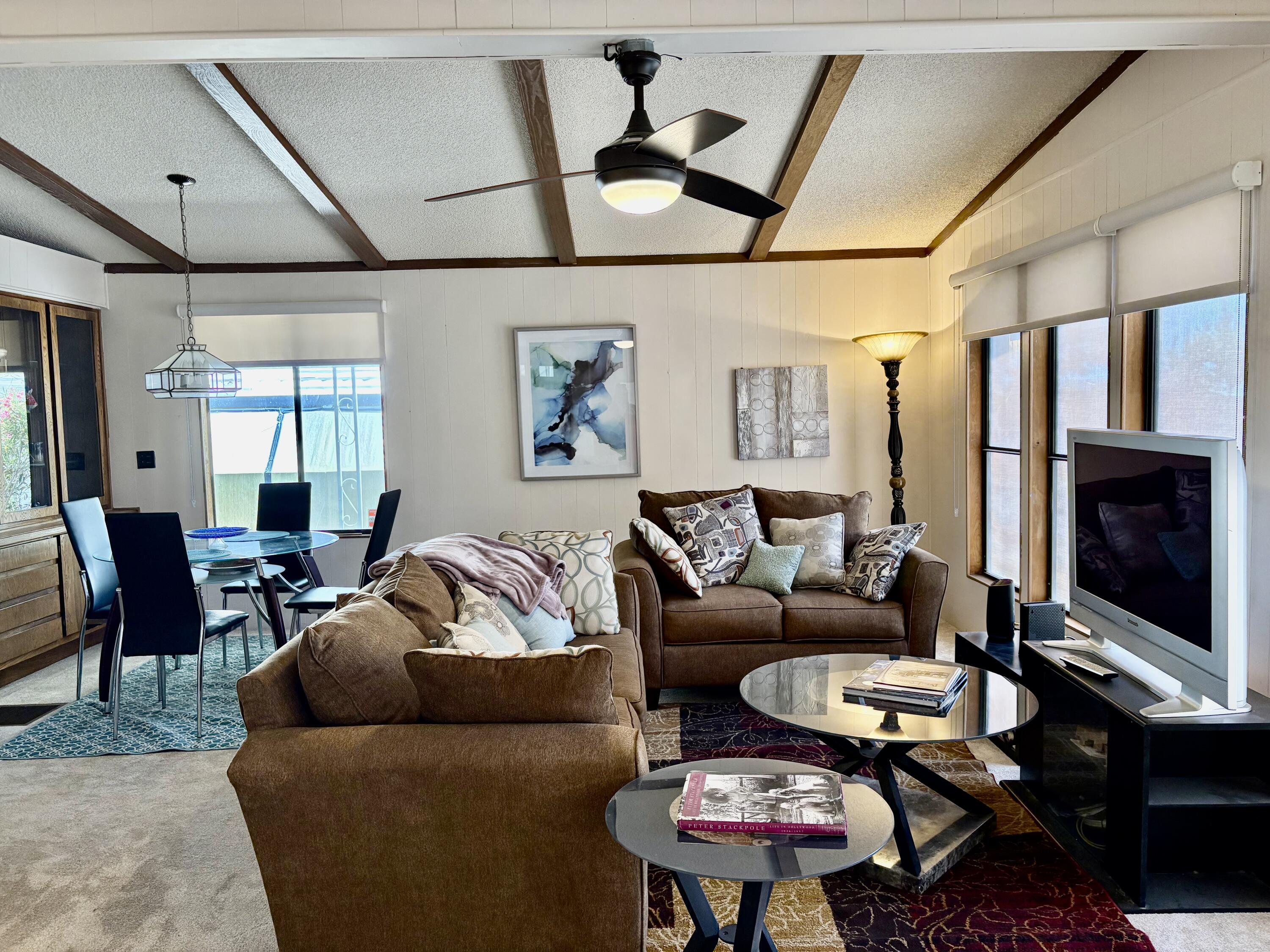 74711 Dillon Road, Unit 387 Desert Hot Springs, CA 92241 - Photo 9 of 50 a living room with furniture a flat screen tv and a table