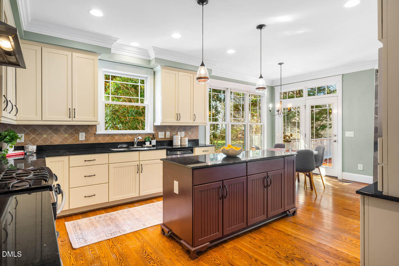 300 Long Meadows Road Chapel Hill, NC 27516 - Photo 13 of 42 a large kitchen with kitchen island granite countertop a stove a sink and dishwasher wooden cabinets with granite countertops