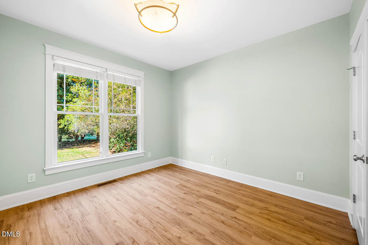 300 Long Meadows Road Chapel Hill, NC 27516 - Photo 32 of 42 an empty room with wooden floor and windows