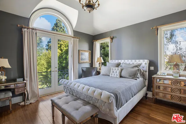 a bedroom with a bed a dresser next to a window