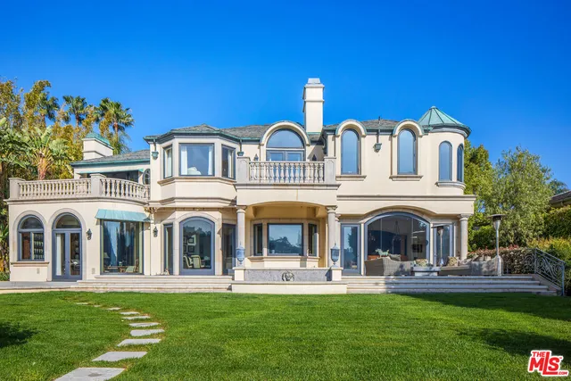 a front view of a house with a garden and plants