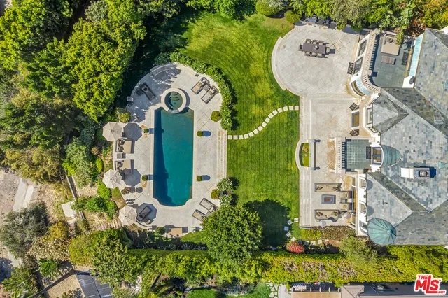 an aerial view of a house with a swimming pool and outdoor seating