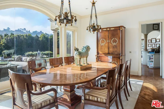 a dining room with furniture a chandelier and wooden floor