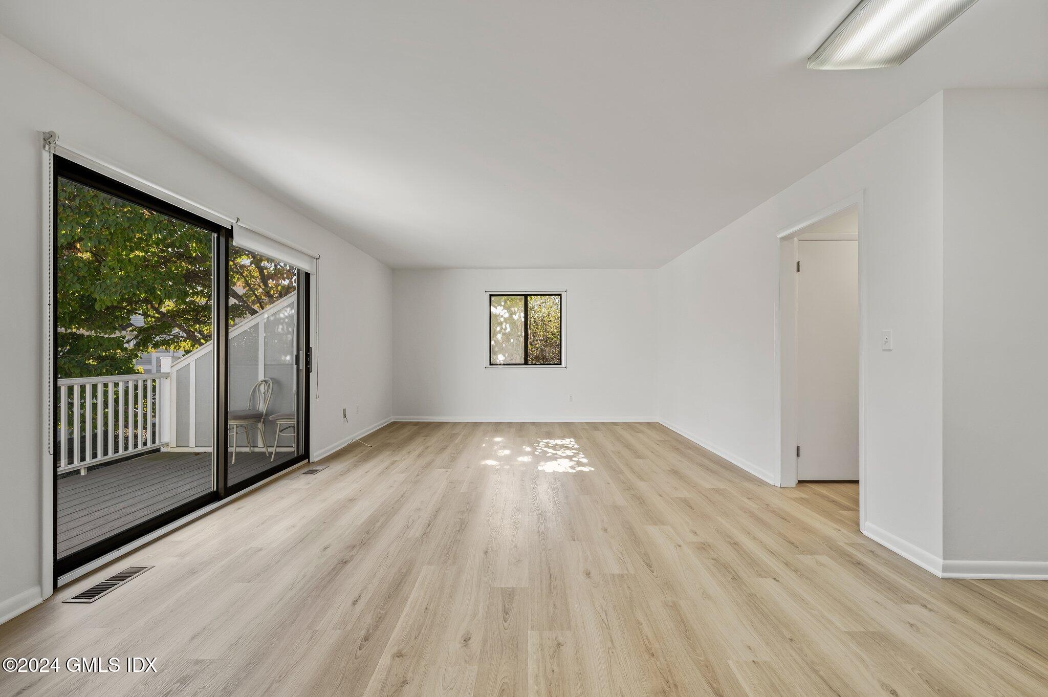75 Silo Circle, Unit 75 Riverside, CT 06878 - Photo 11 of 53 an empty room with wooden floor and windows