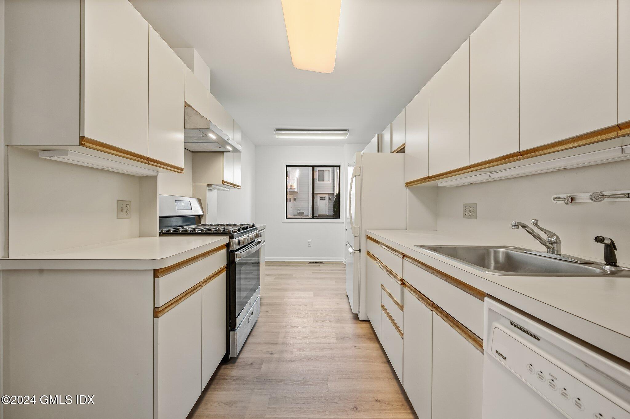 75 Silo Circle, Unit 75 Riverside, CT 06878 - Photo 16 of 53 a kitchen with granite countertop a sink and white cabinets