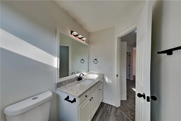a bathroom with a granite countertop sink and a mirror