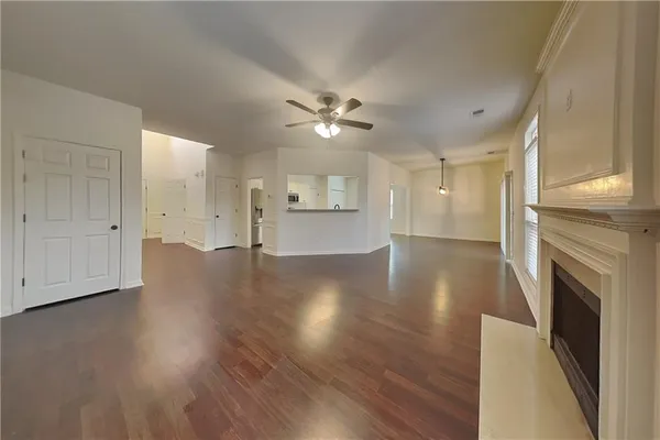 a view of empty room with wooden floor and fireplace