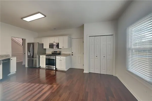 a kitchen with stainless steel appliances a refrigerator and wooden floor