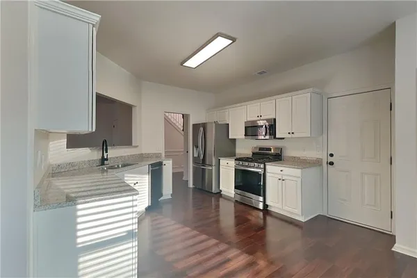 a kitchen with stainless steel appliances granite countertop a refrigerator and a stove top oven