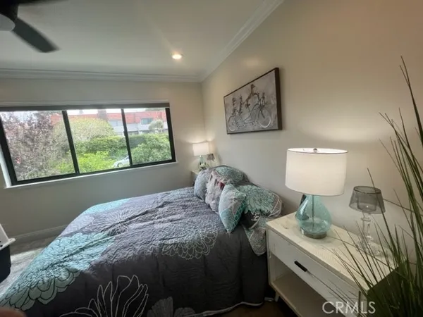 a bedroom with a bed and a lamp on dresser