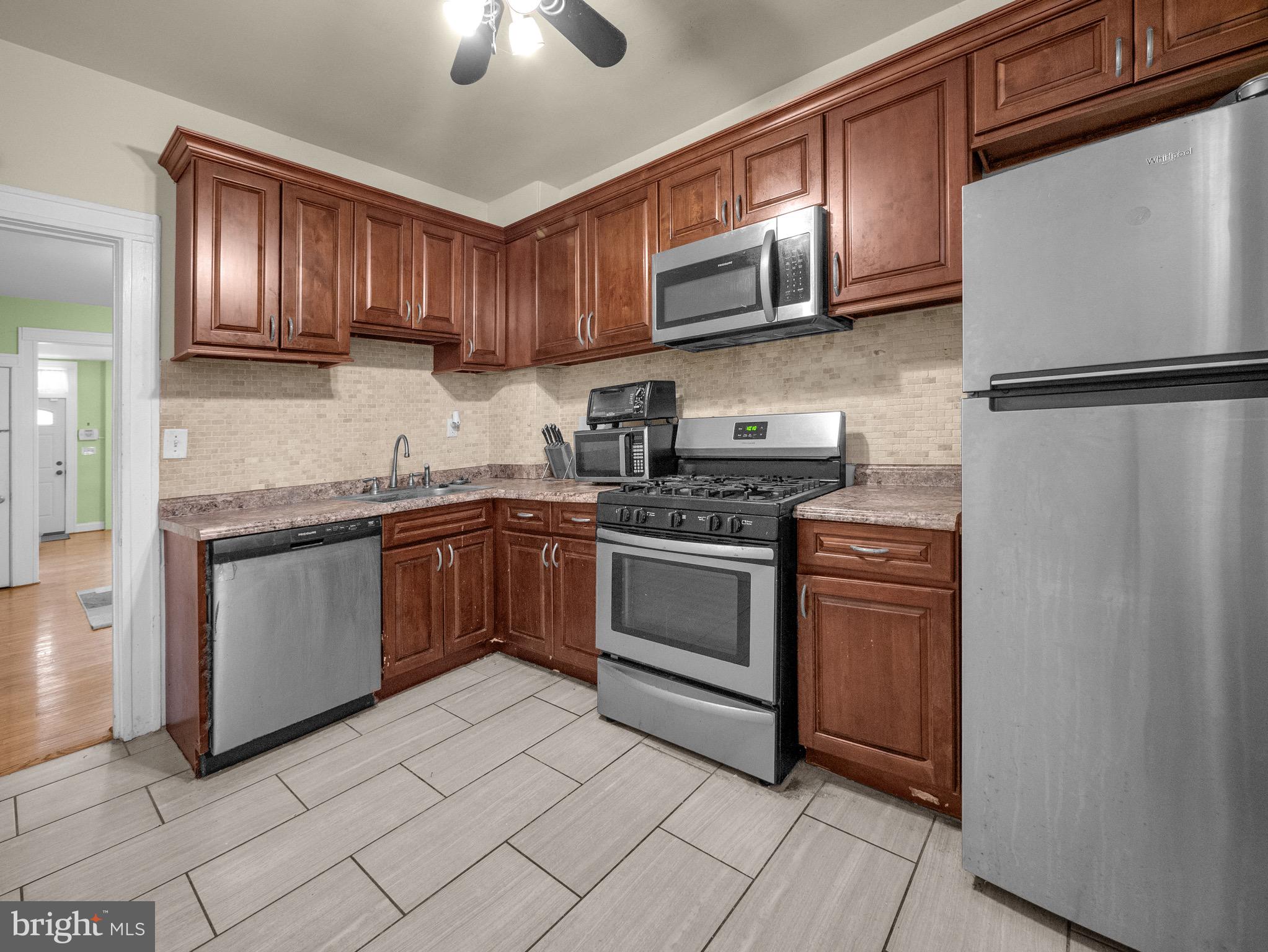 a kitchen with stainless steel appliances granite countertop a stove microwave sink and refrigerator