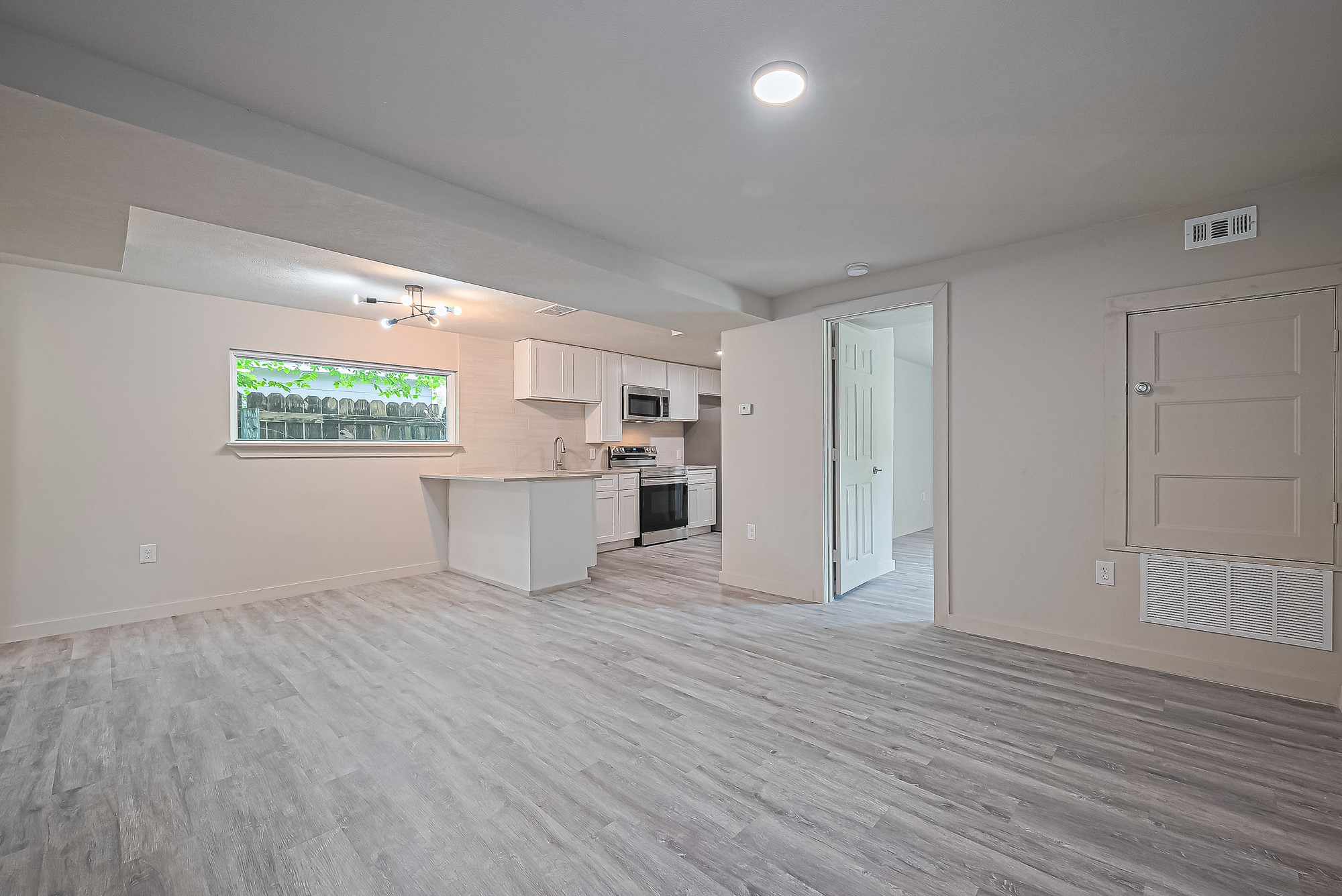 4013 Ranch Street, Unit 1 Houston, TX 77026 - Photo 3 of 16 a view of a kitchen with wooden floor and windows