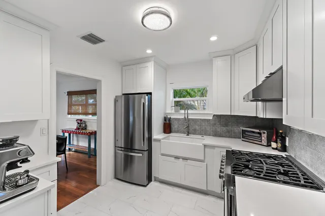 a kitchen with a refrigerator and a stove top oven