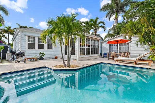 a view of a house with swimming pool and sitting area