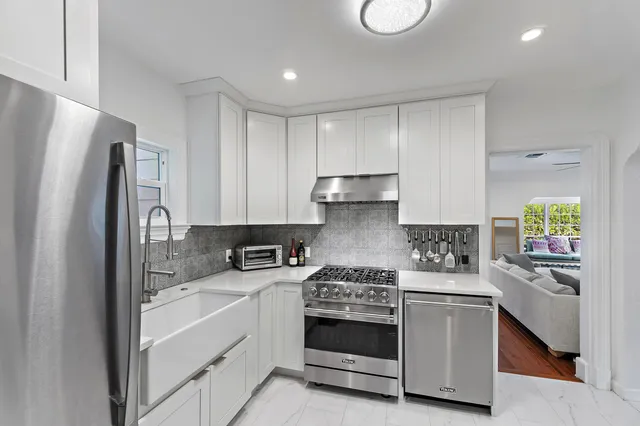 a kitchen with stainless steel appliances a stove a sink and a refrigerator