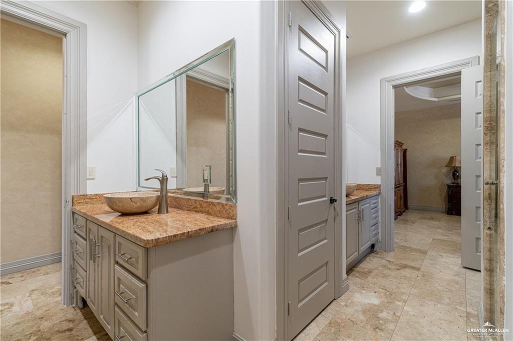 1205 Travis Street Mission, TX 78572 - Photo 32 of 45 a bathroom with a granite countertop sink and a mirror