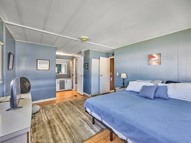 a bedroom with a bed and wooden floor