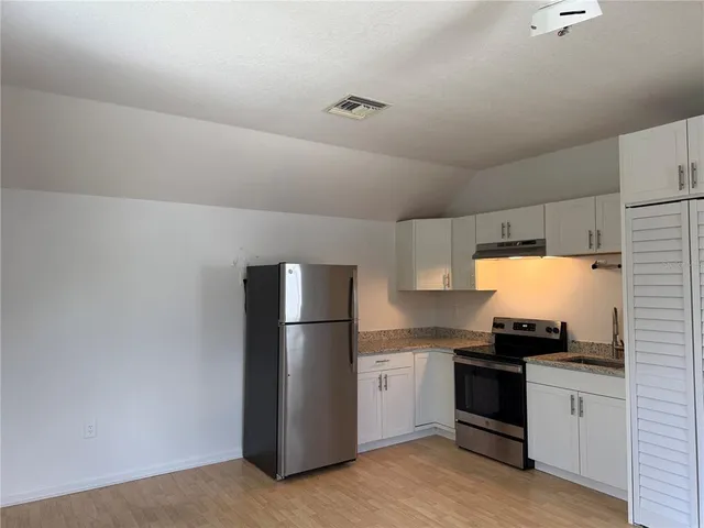 a kitchen with a refrigerator and a stove top oven
