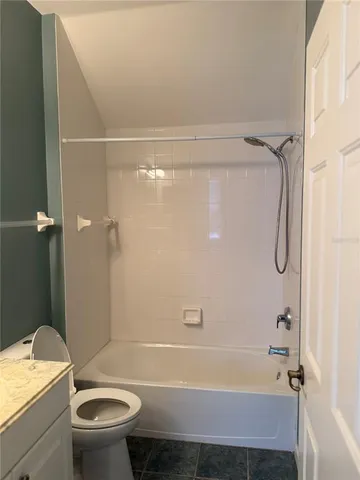 a bathroom with a granite countertop bathtub shower sink and toilet