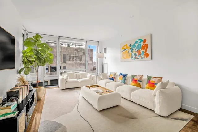 a living room with furniture a flat screen tv and a large window