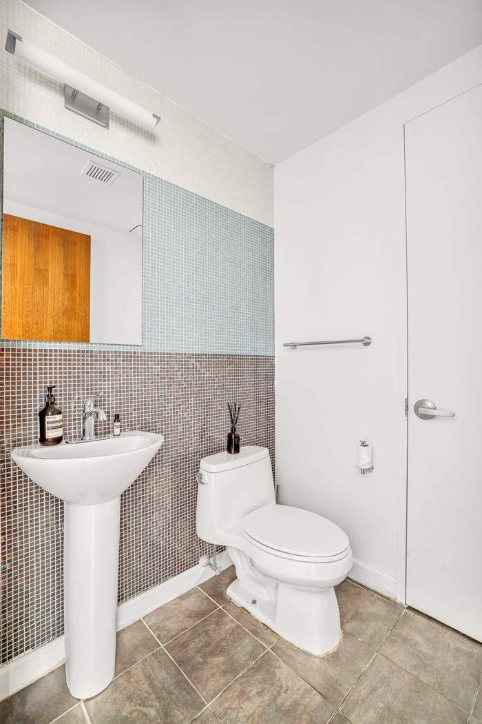 261 West 28th Street, Unit 9C Manhattan, NY 10001 - Photo 5 of 12 a bathroom with a sink toilet and shower