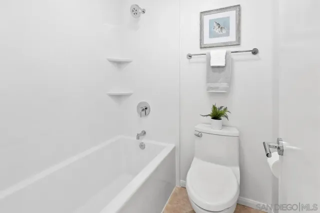 a white toilet sitting next to a white tub